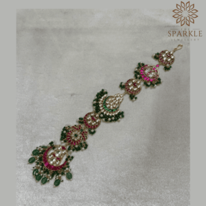 Gold plated bridal hair braid with pink and green stones and hanging beads for traditional Indian hairstyles.