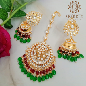 Green and red Pachi Kundan jhumka earrings with maangtikka set in 22K gold plated Jadau jewellery by The Sparkle Jewellery